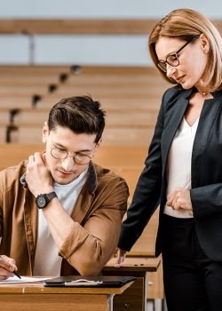 female-university-teacher-looking-at-male-student-8QYL6WQ.jpg